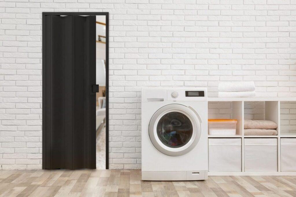 Porta sanfonada preta de PVC em ambiente interno, com design moderno e elegante, destacando praticidade e otimização de espaço com a qualidade e durabilidade da Permatti.