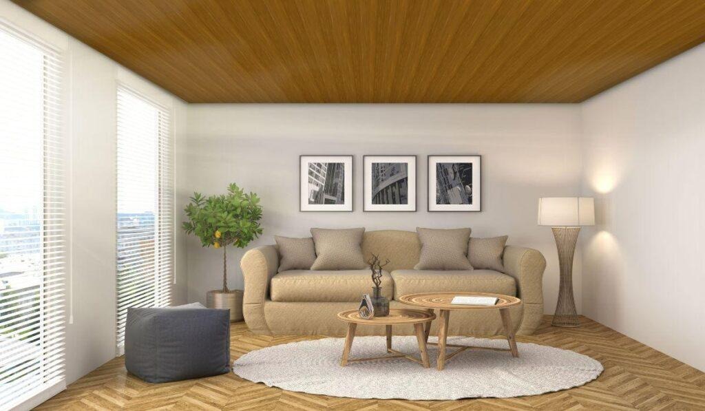 Sala com forro de PVC amadeirado da PERMATTI. O teto em tom de madeira harmoniza com o piso espinha de peixe, paredes brancas e móveis neutros, criando um ambiente acolhedor.